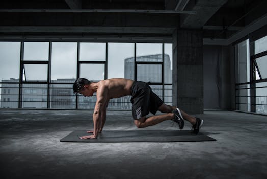 Training core muscles. Fit man doing mountain climbers exercise inside a modern gym.