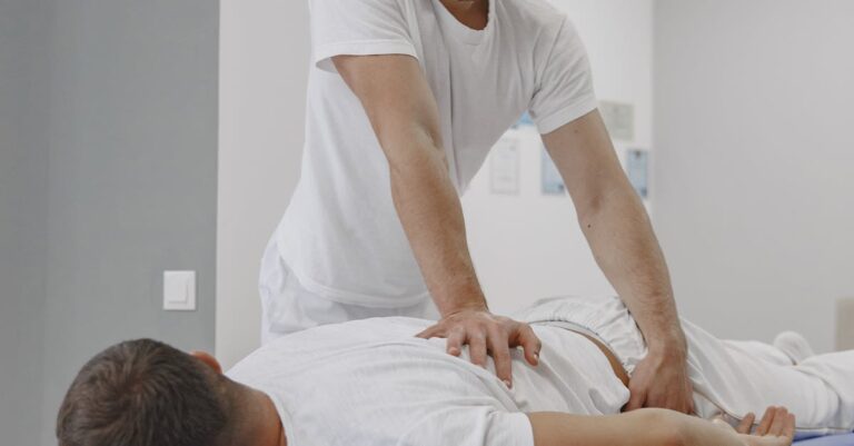 Chiropractor conducting a therapy session for back pain relief in a massage room.