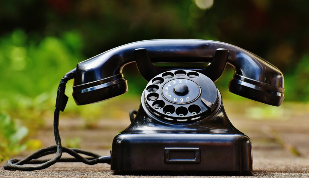 Vancouver Chiropractor at Aquarius Chiropractic 3 Contact our Vancouver chiropractor. Close-up of a classic black rotary phone outdoors with a blurred green background.