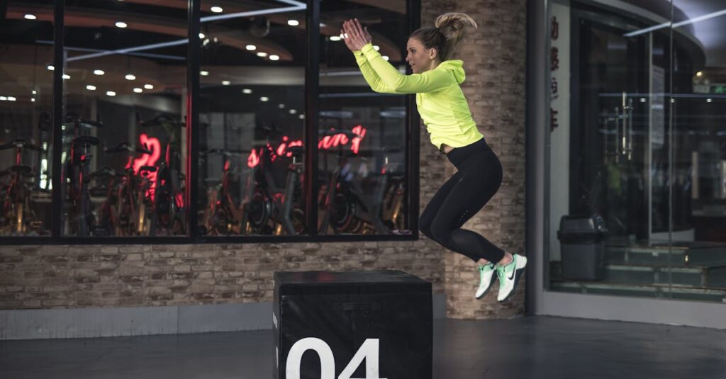 Fit young woman in sports wear executing a box jump indoors, promoting fitness and health in a modern urban gym. Ballistic training exercises, chiropractic exercise coach.