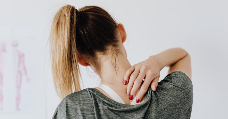 A woman in casual clothing holds her neck, indicating pain or discomfort due to scoliosis.