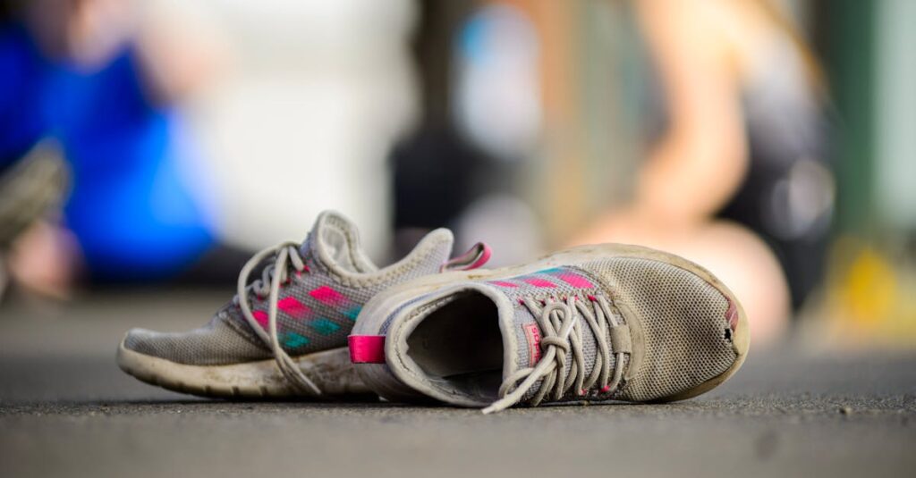 Detailed view of worn sneakers on a street, with a blurred background of people. foot chiropractor, orthotics in Vancouver
