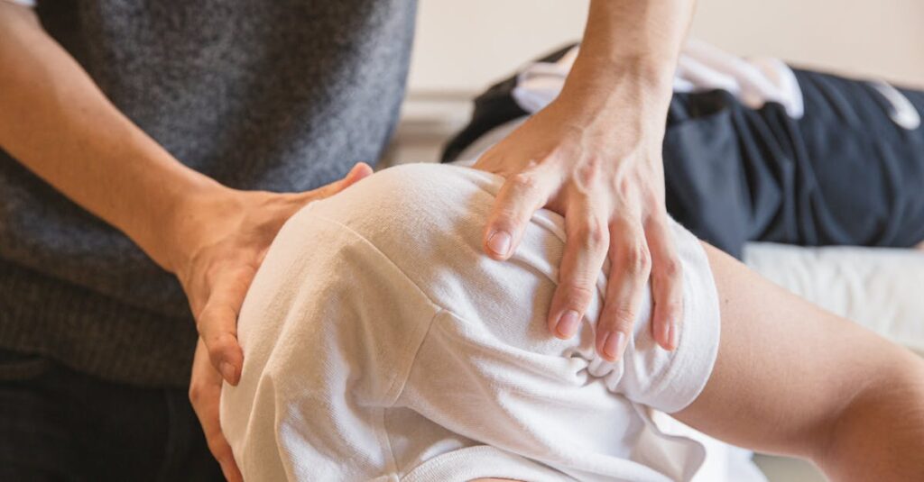 Chiropractor treating the shoulder of a male patient lying on a chiropractic treatment table. Benefits of Chiropractic